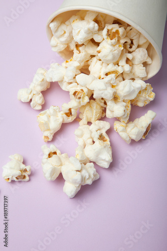 Salty popcorn on a bright pink background.