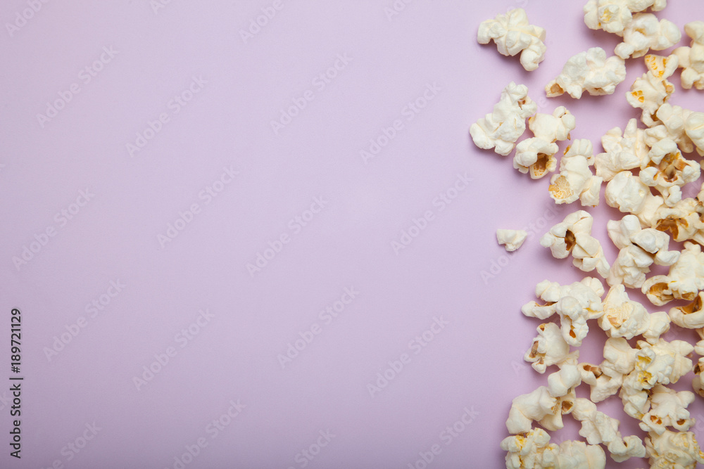 Spilled popcorn on a pink background, empty space for text.