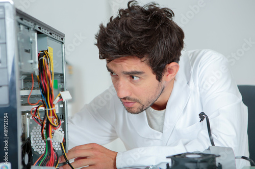 Computer repairman looking confused