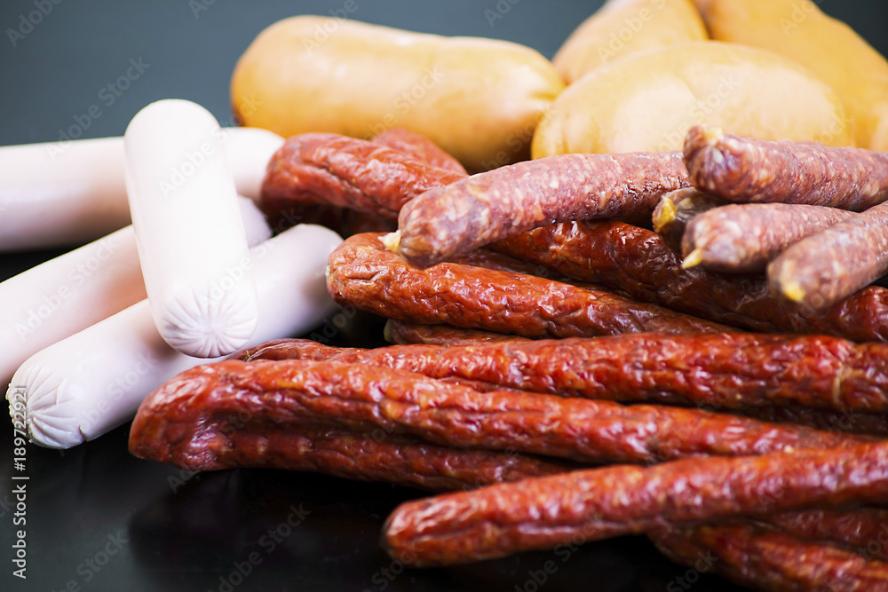 different meat sausages on a black background different meat sausages on a black background