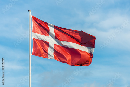 Danish flag waggling in the wind with sky in background