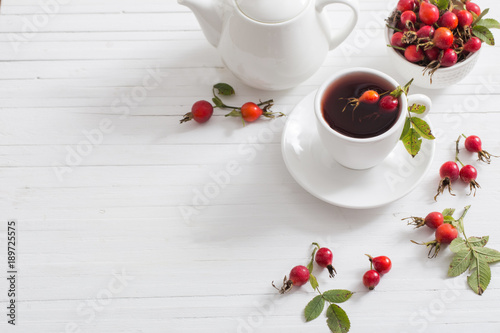 tea with berries of a dogrose on a wooden background