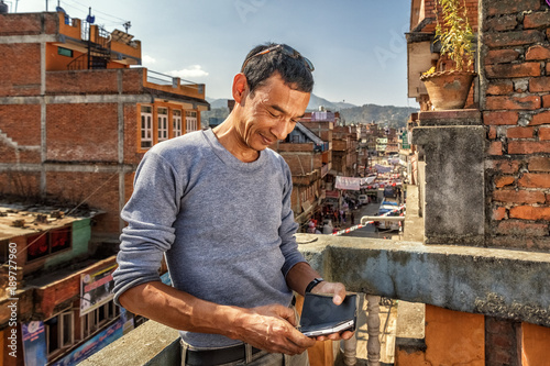 Man Checks his Smartphone, Panauti, Nepal photo