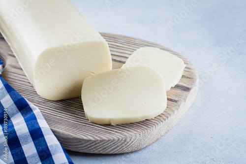 White mozzarella on blue concrete stone background table. Healthy Food Concept. Daily product. Copy space