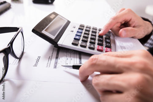 Businessman's Hands Calculating Invoice