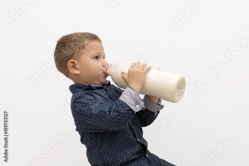 Schilderij op canvas Smiling child boy drinking milk