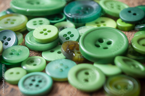 boutons de couture de couleur verte sur table en vieux bois 