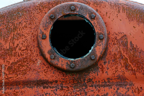 Close up background of rusty metal tank with rusty circular hole