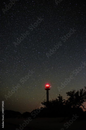 Silhouette of the Lighthouse and trees against the background of the starry sky