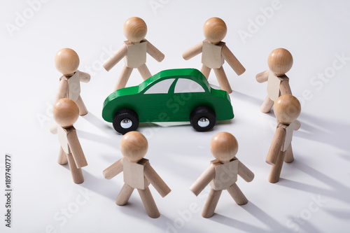 Green Car Surrounded By Human Figures