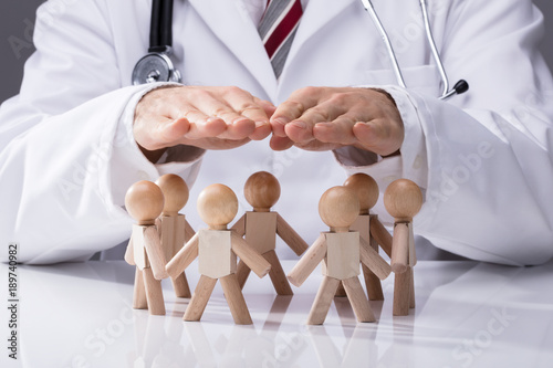 Fotografie Doctor Protecting Wooden Figures