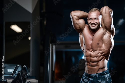 Brutal strong bodybuilder athletic men pumping up muscles with dumbbells.