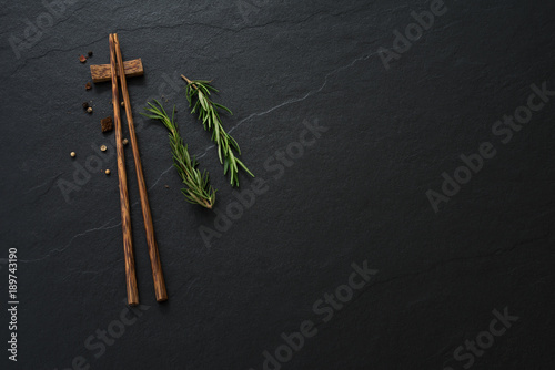 space wood chopsticks and vegetable on dark background