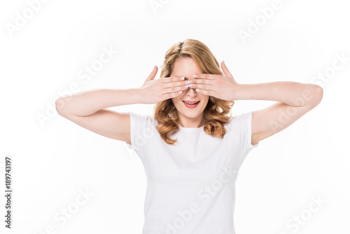 obscured view of caucasian woman covering eyes with hands isolated on white