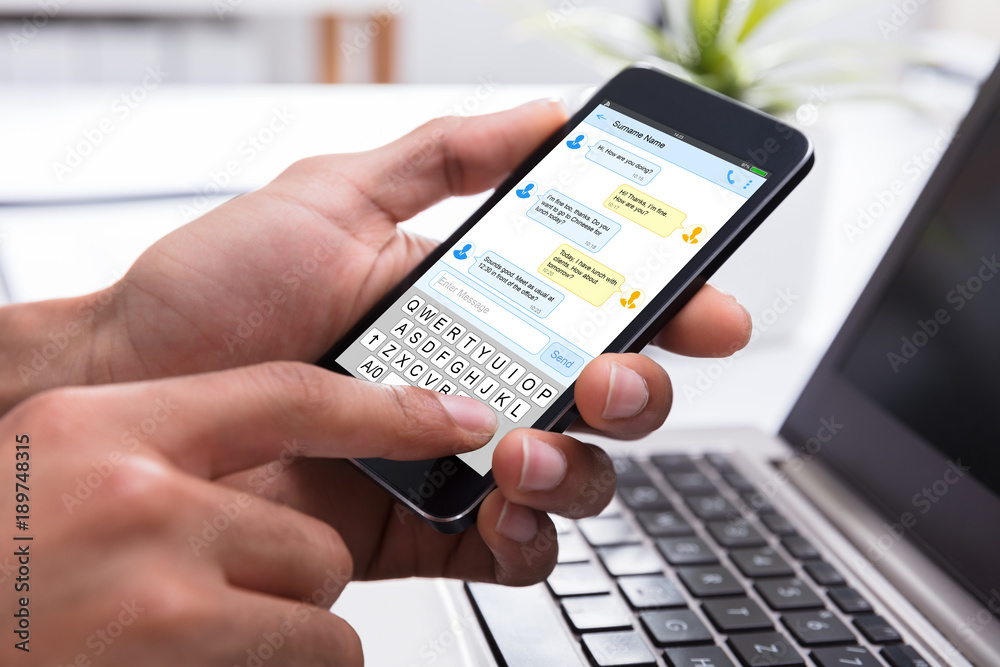 Businessperson Typing Text Message On Mobile Phone