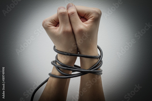 Fotografie Hands tied with cable.Technology addiction concept