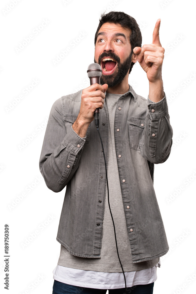 Handsome man with beard singing with microphone on white background Handsome man with beard singing with microphone on white background