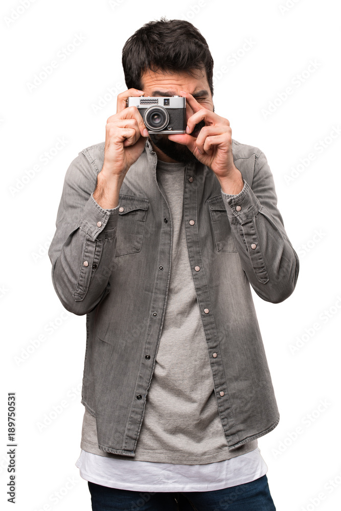Handsome man with beard photographing on white background