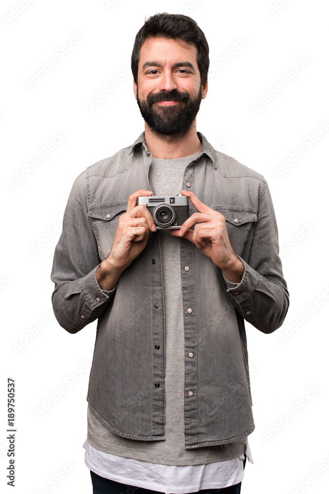 Handsome man with beard holding a camera on white background Handsome man with beard holding a camera on white background