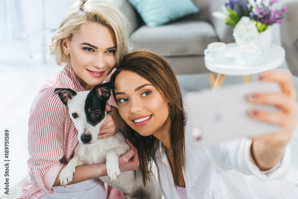 smiling girls taking selfie with jack russell terrier dog on smartphone smiling girls taking selfie with jack russell terrier dog on smartphone