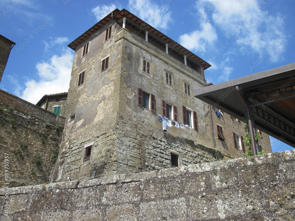 Mura di Pitigliano con palazzo e panni stesi