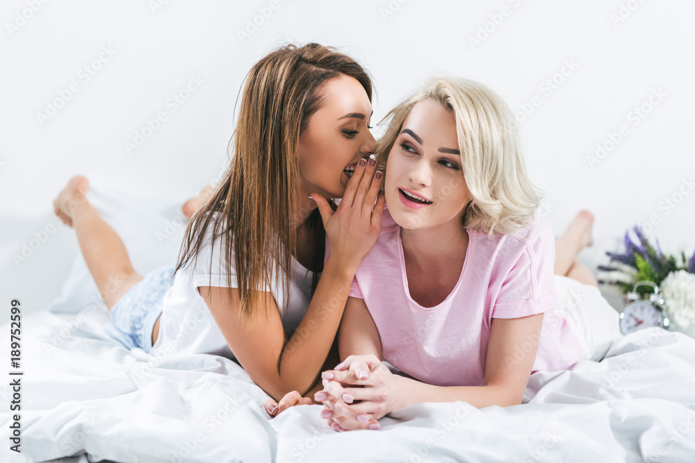 beautiful girls gossiping together in bedroom