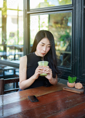woman dinking ice green tea latte in the cafe