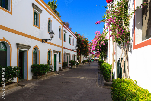 Fototapeta Naklejka Na Ścianę i Meble -  Wonderful alley with colorful flowers, doors and windows in Puerto De Mogan on Gran Canaria island.