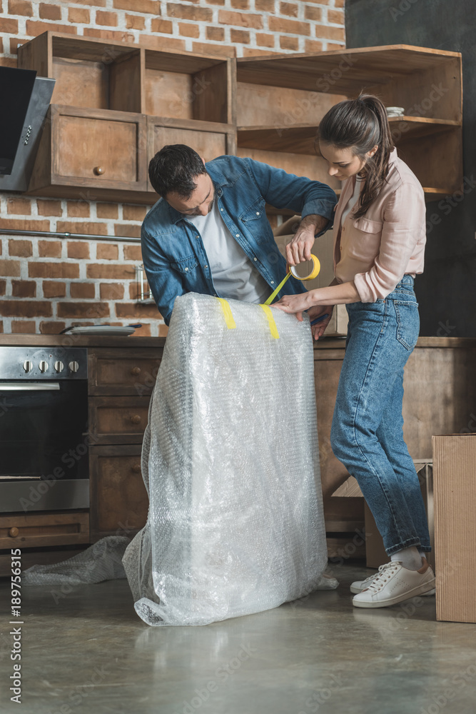 young couple packing picture while moving home