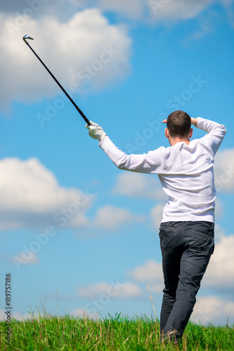 golfer watching where his ball flew to the field, view from the back