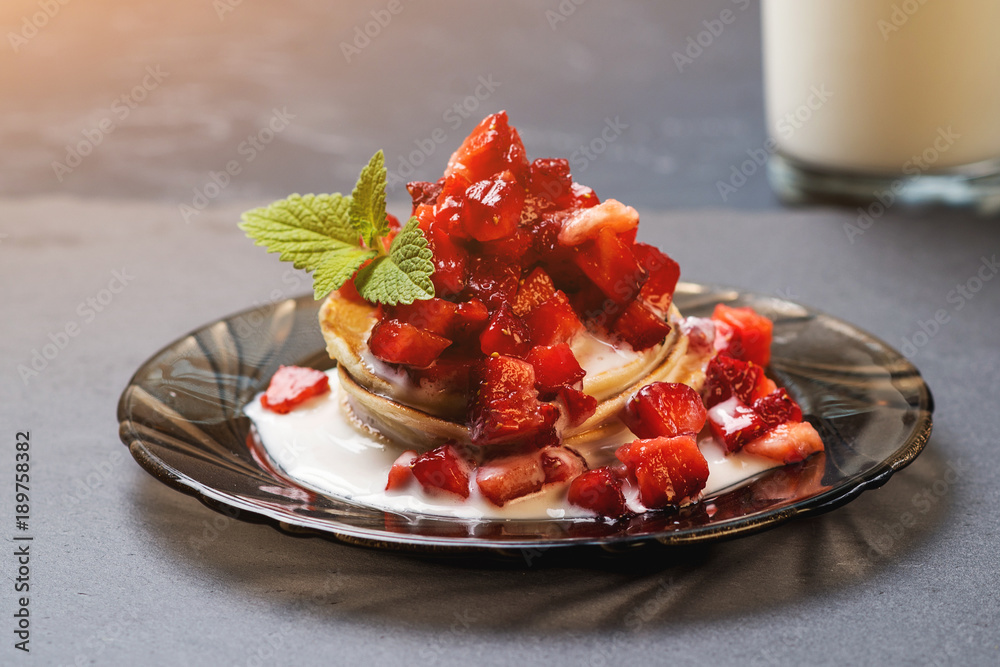 Stack of pancakes with ripe strawberries and pouring by jogurt. Stack of pancakes with ripe strawberries and pouring by jogurt.