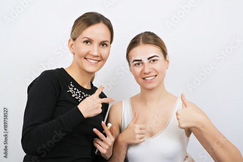 Young woman and beautician during an eyebrow correction procedure.