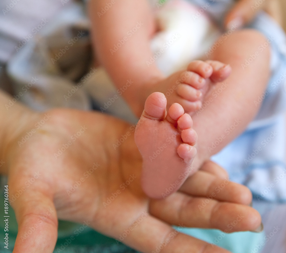 Infant heels in mother's hands Infant heels in mother's hands