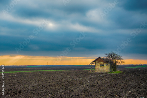 Indjija, Serbia January 18, 2018: Abandoned house in the field and sunset