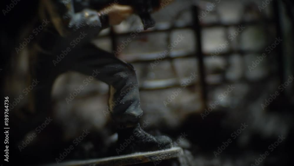 Toy soldier in gray uniform stands near the fence