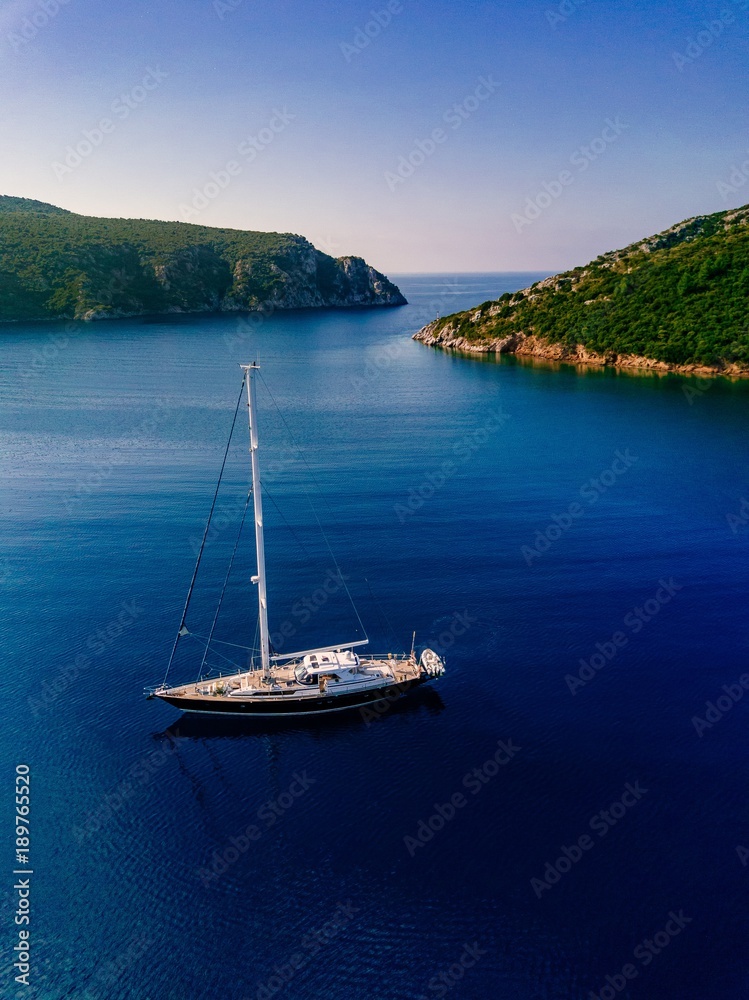 Aerial view to Yacht in deep blue sea.