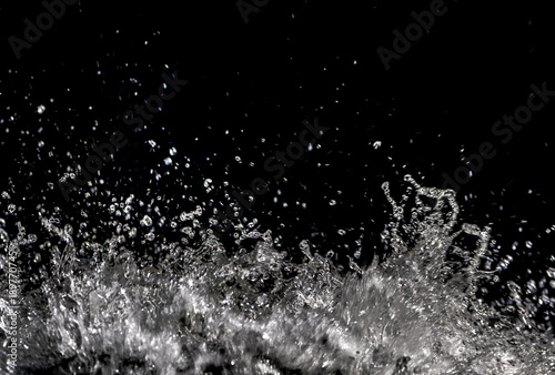 Water splash transparent on black background with copy space, sparkling water drops detail, shot taken in nature, waterfall at Plitvice lakes, Croatia, Europe