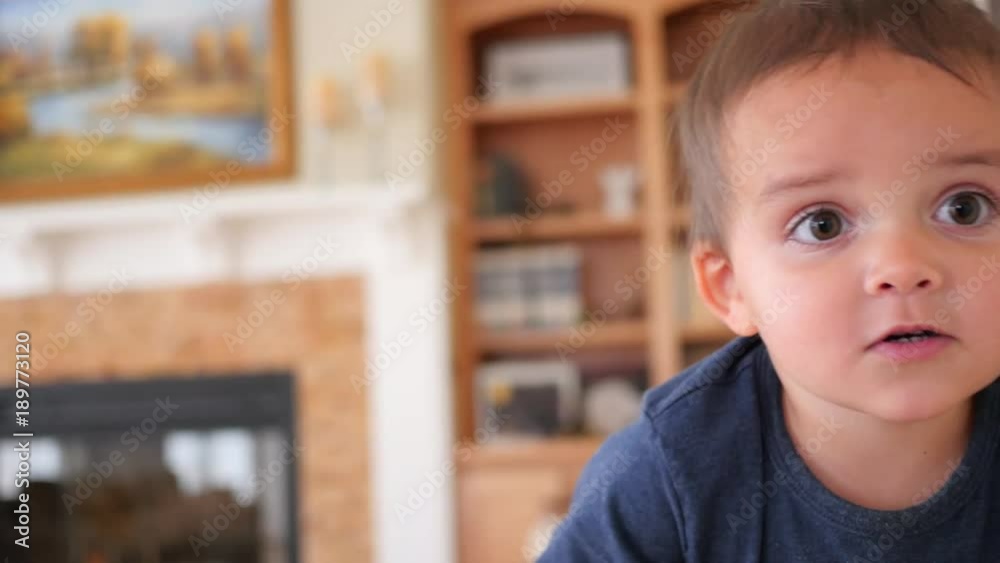 A cute little boy toddler plays on a ipad on couch A cute little boy toddler plays on a ipad on couch