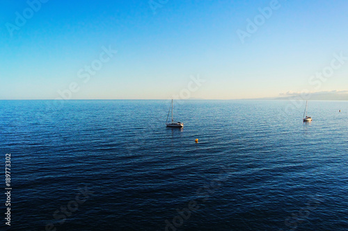 Yacht on the horizon of the spacious blue sea. With free space for text.