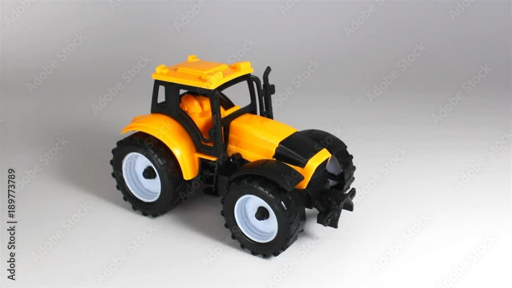 Yellow tractor ride and stop in front on white background Yellow tractor ride and stop in front on white background