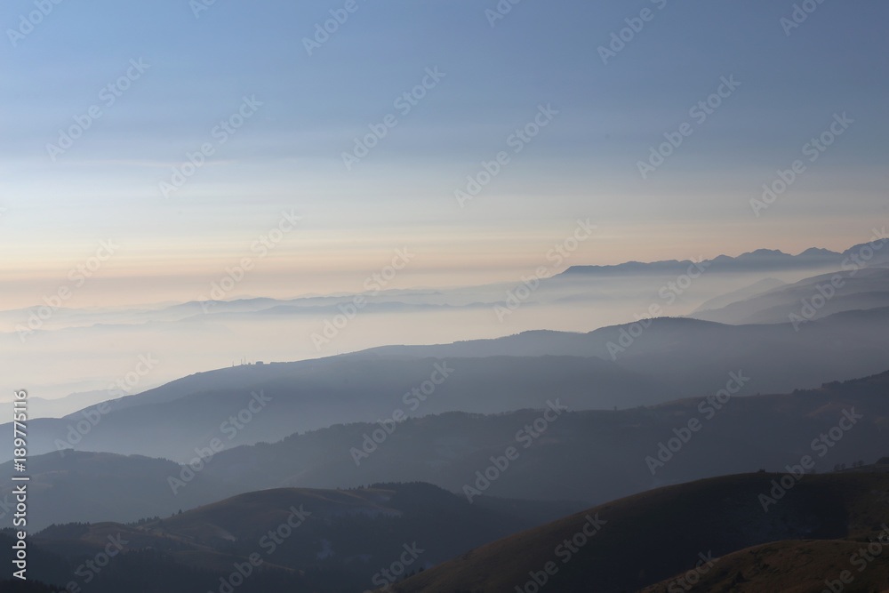 Mountains at sunrise surrounded by fog