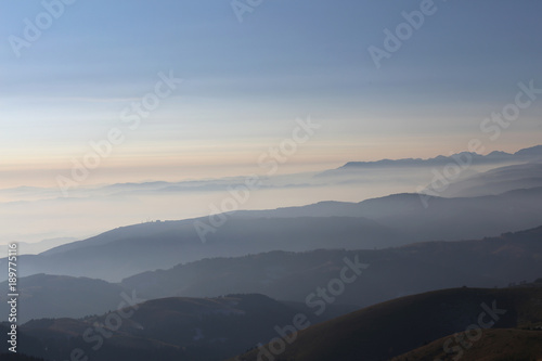 Mountains at sunrise surrounded by fog