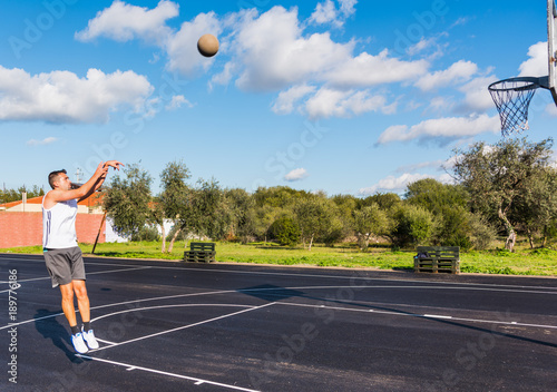Basketball player jump shot in a playground