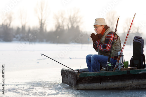 Fisherman in boat worming hands
