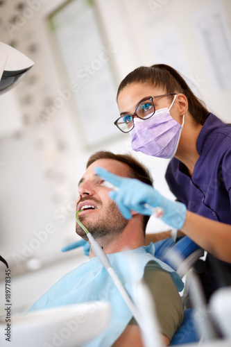 Female dentist showing to patient teeth problem