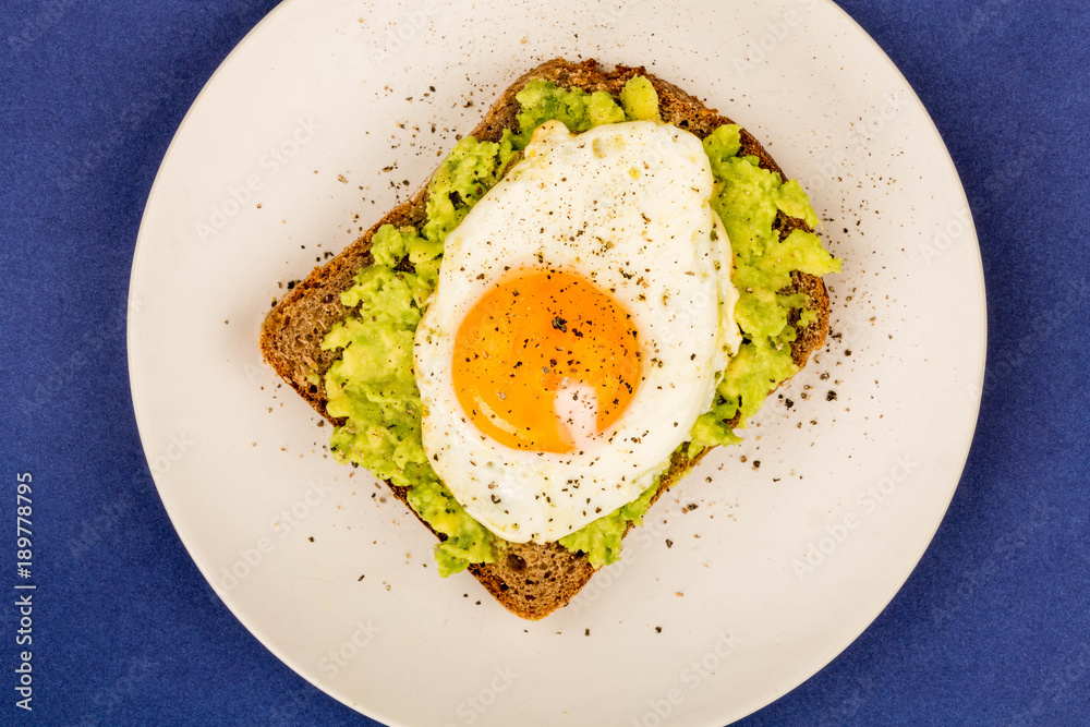 Fried Egg Sunny Side Up on Crushed Avocado And Rye Bread Open Faced Sandwich Fried Egg Sunny Side Up on Crushed Avocado And Rye Bread Open Faced Sandwich