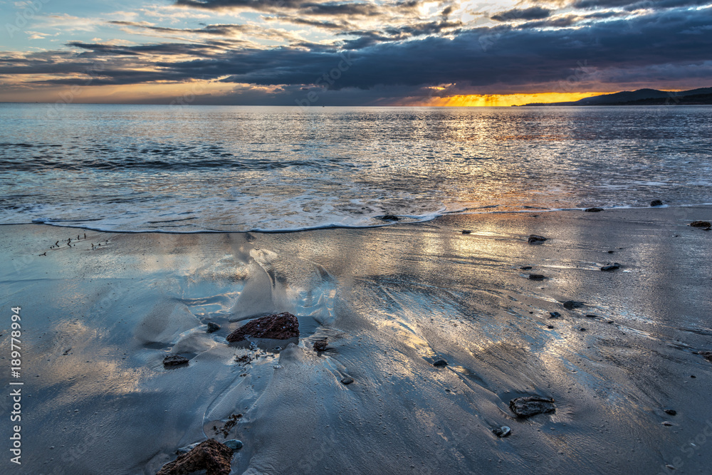Rocks and sand in Alghero shore at sunset Rocks and sand in Alghero shore at sunset
