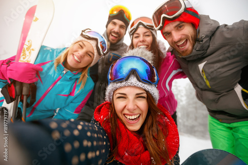 Group of friends making selfie and having fun on the snow