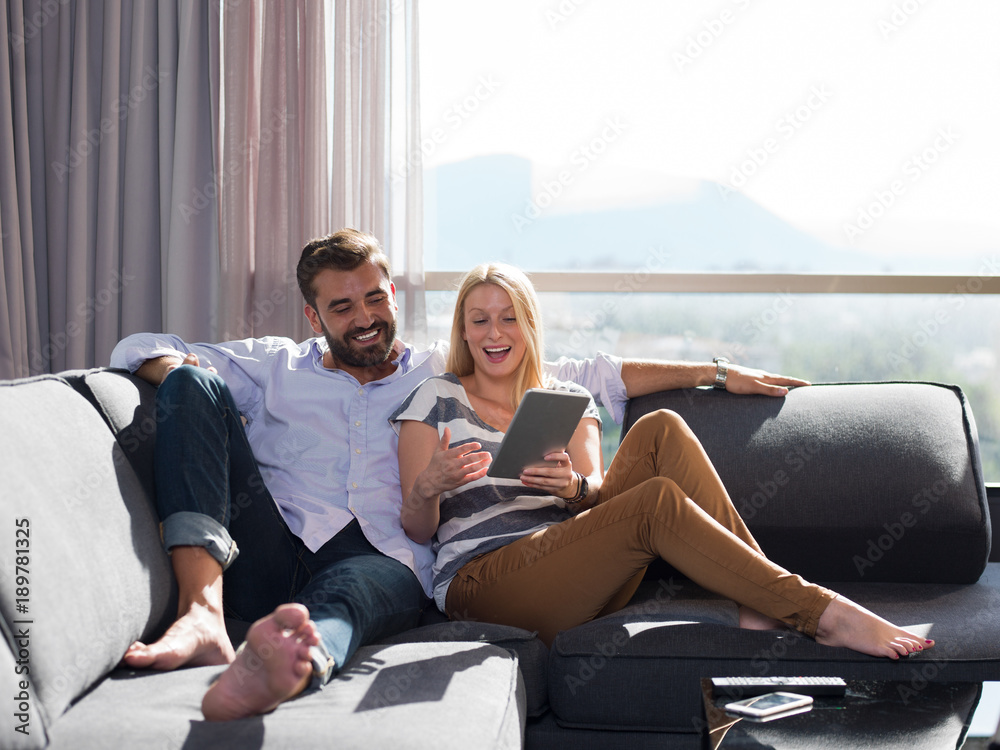 couple relaxing at home with tablet computers couple relaxing at home with tablet computers
