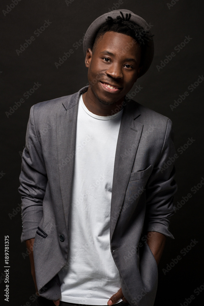 Close-up portrait of handsome black man with charming smile. Studio shot of well-dressed african guy wears hat and jacket. Close-up portrait of handsome black man with charming smile. Studio shot of well-dressed african guy wears hat and jacket.